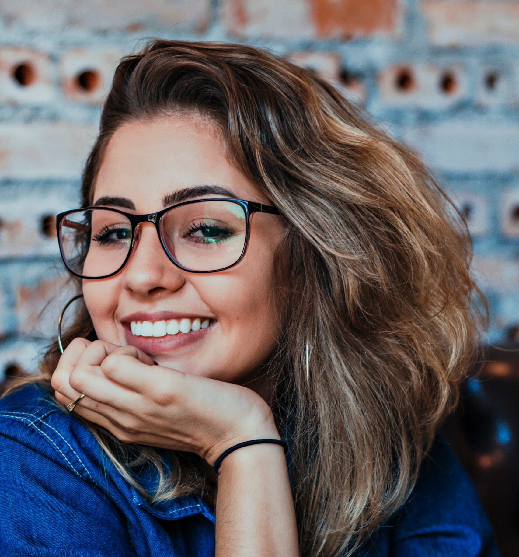 Woman in glasses smiling at the Bayshore Family Dental office