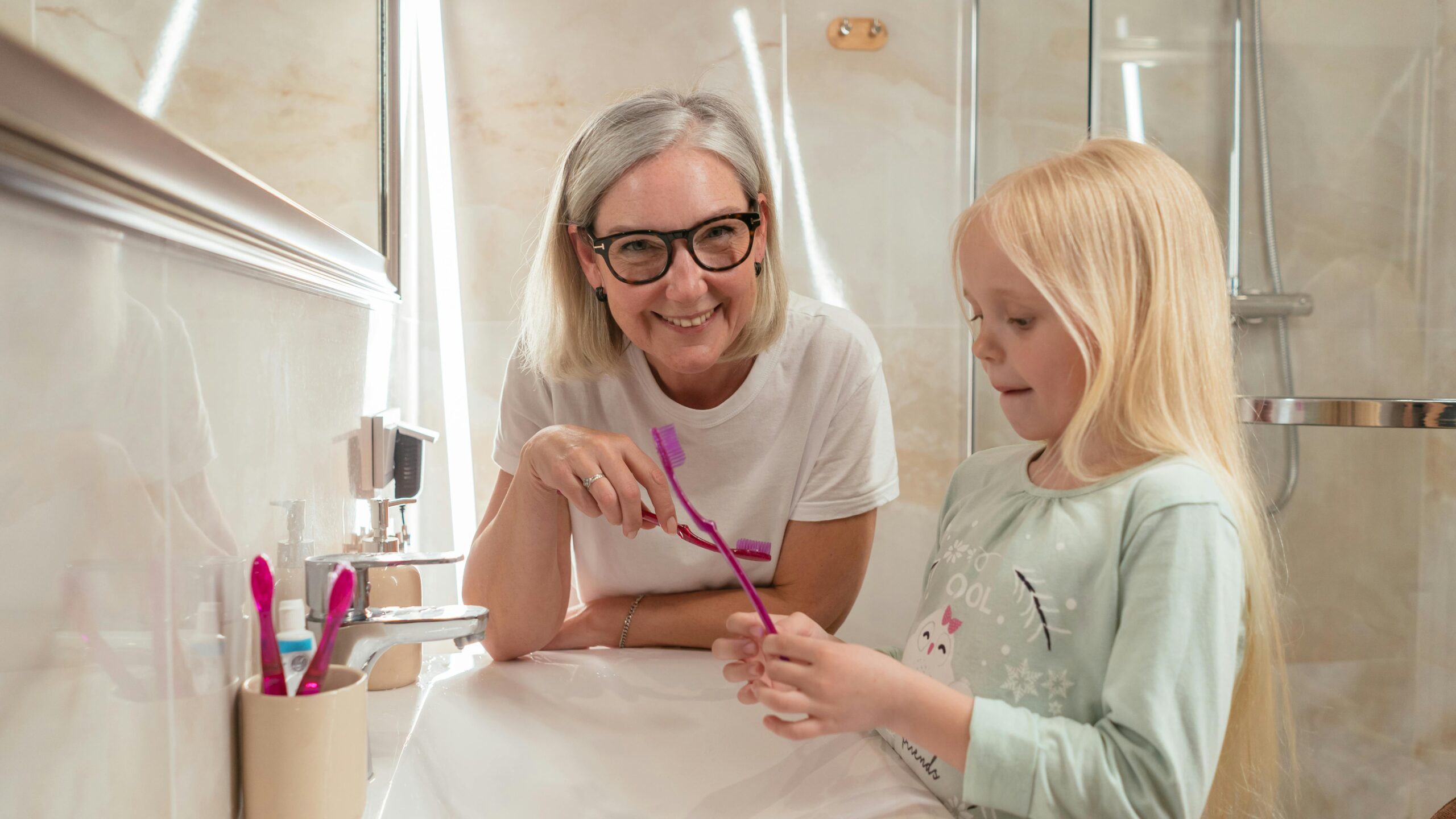 senior patient brushing her dental implants in dunedin with a soft toothbrush